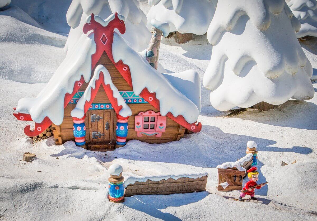 Peter in front of his cottage in snowy surroundings a small figure of Peter cautiously creeps through the snow during the fairy boat ride in Fantasyland