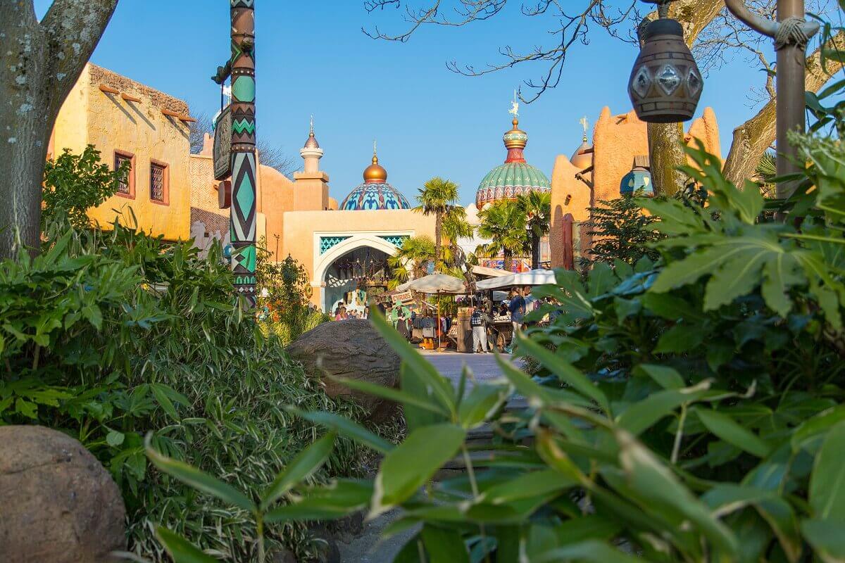 View of the Arabian bazaar from afar View through plants to the buildings of the bazaar in Adventureland