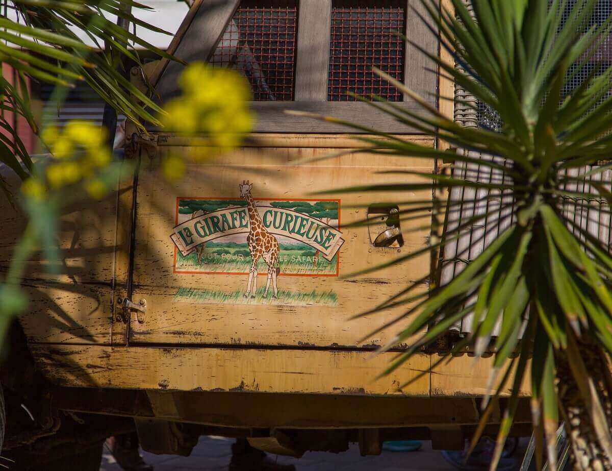 Yellow truck in front of the shop La Girafe Curieuse Close-up of a motif with the lettering La Girafe Curieuse on a yellow truck