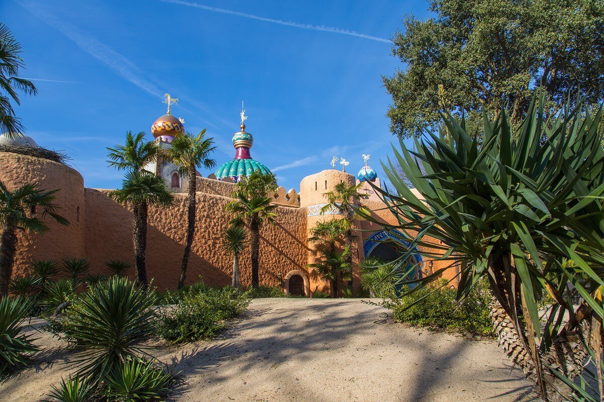 Sand dune and entrance to Adventureland Side view of a sand dune and desert plants left of the entrance to Adventureland