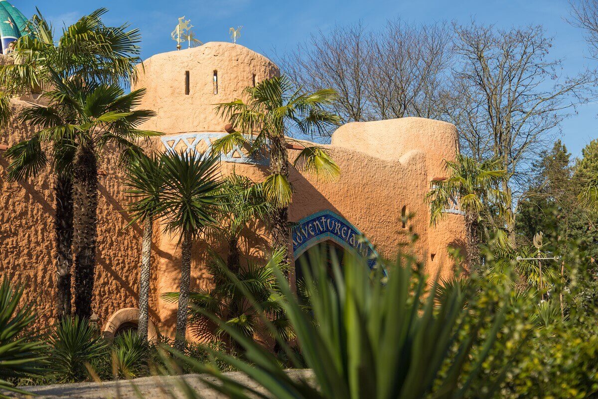 Passage to Adventureland Side view through bushes to the gate of Adventureland