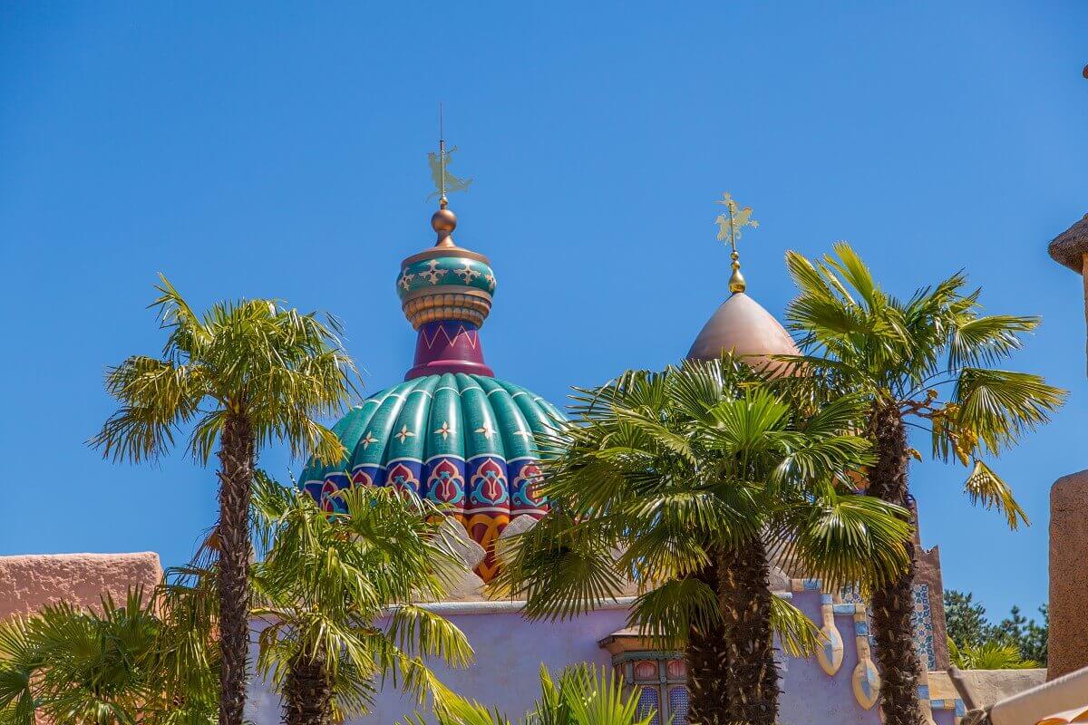 Colorfully decorated roof of the Arabian bazaar View of palm trees and a colorfully decorated roof in Adventureland