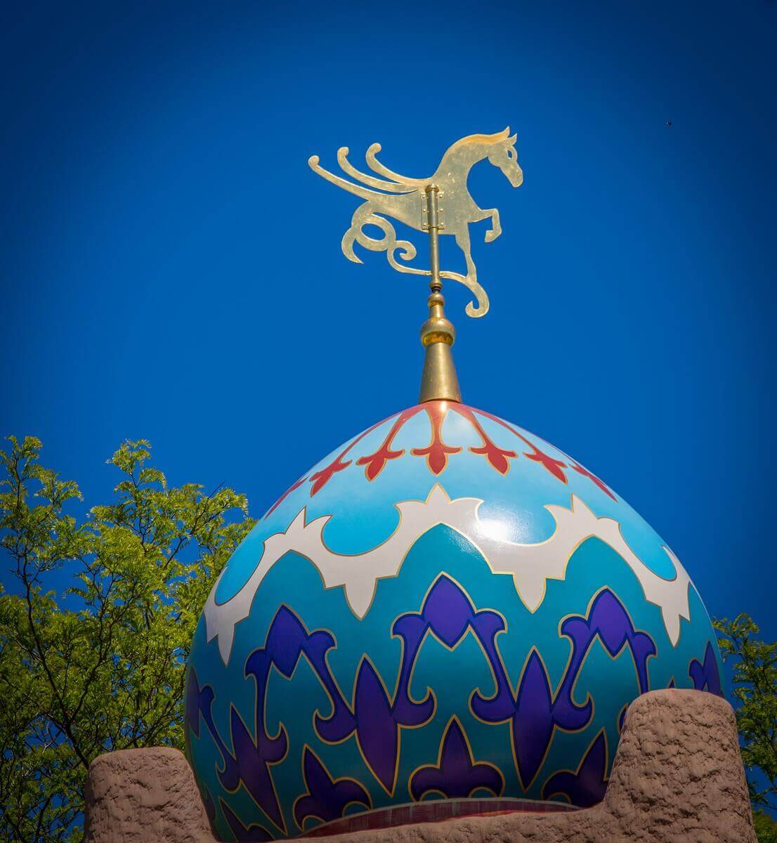 Colorful roof with gold decoration View of a colourful dome with filigree decoration and a golden decoration in the shape of a horse