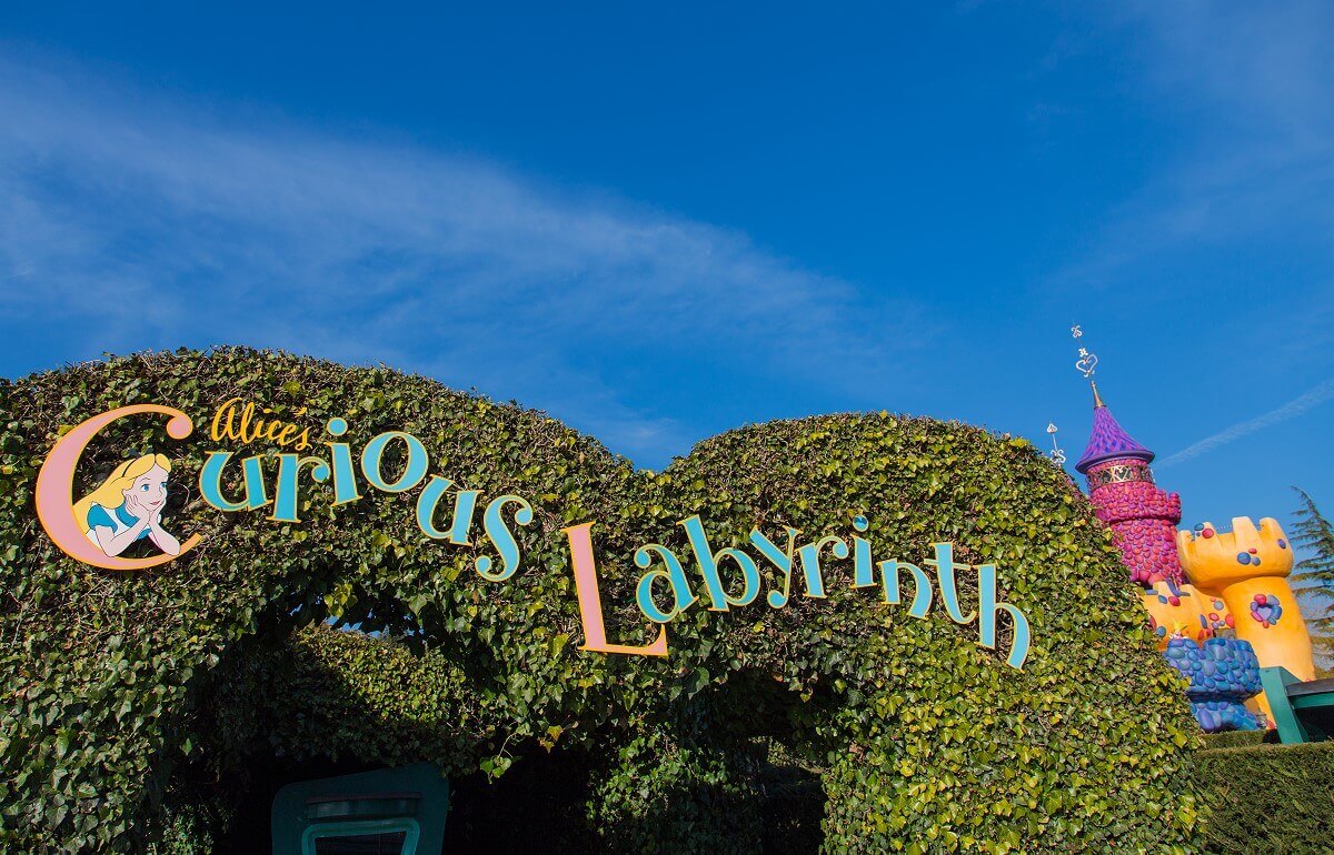 Sign above the entrance above the entrance to the labyrinth, the words Alice's Curious Labyrinth are written in colourful letters on a large hedge.