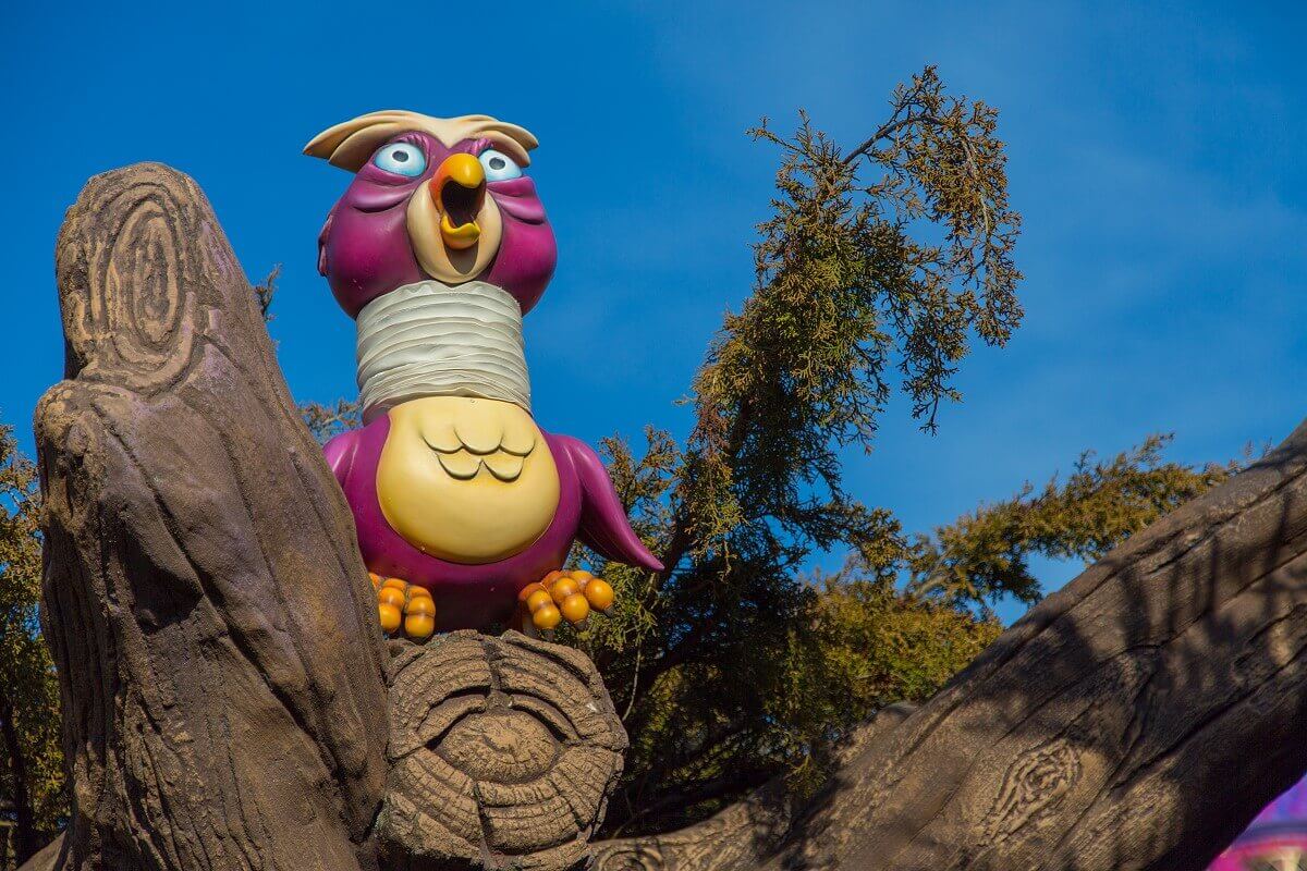 Owl figure in maze on a tree trunk in Alice's maze sits a colourful owl figure with a funny accordion neck