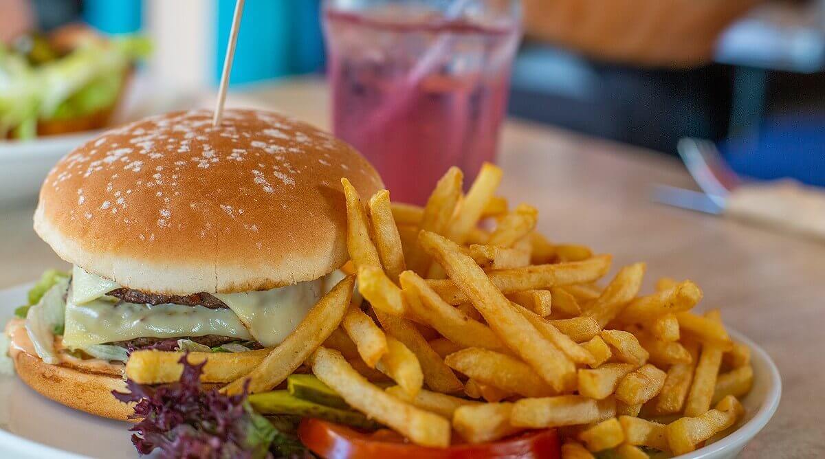 Burger with fries and a cherry Sprite Chesseburger with two patties and fries on the side. In the background is a Cherry Sprite