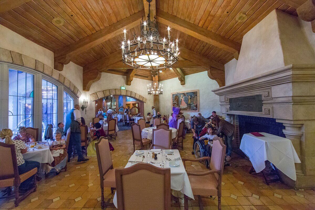 Sitting area in an adjoining room in a smaller side room of the Auberge de Cendrillon you can see several tables and a big fireplace