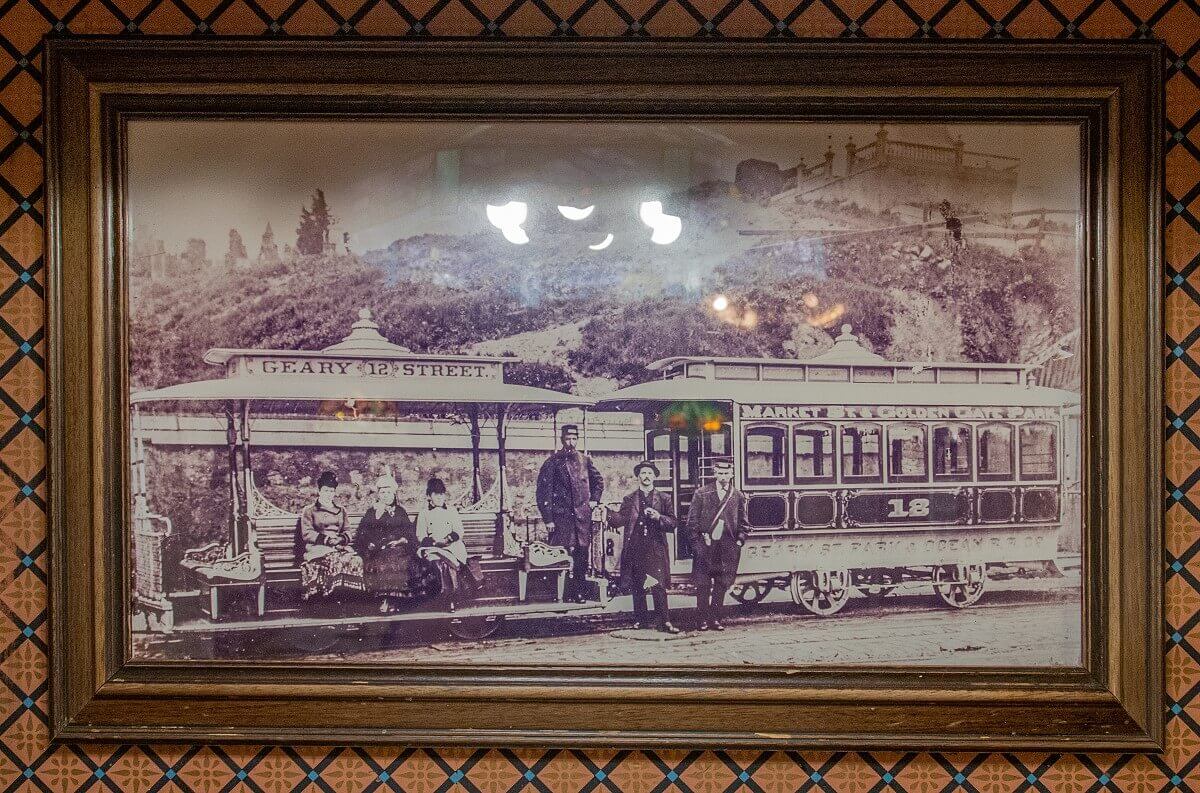 Historical photo of a tram Historic photo of a San Francisco streetcar with two cars, four passengers, and two crew members.