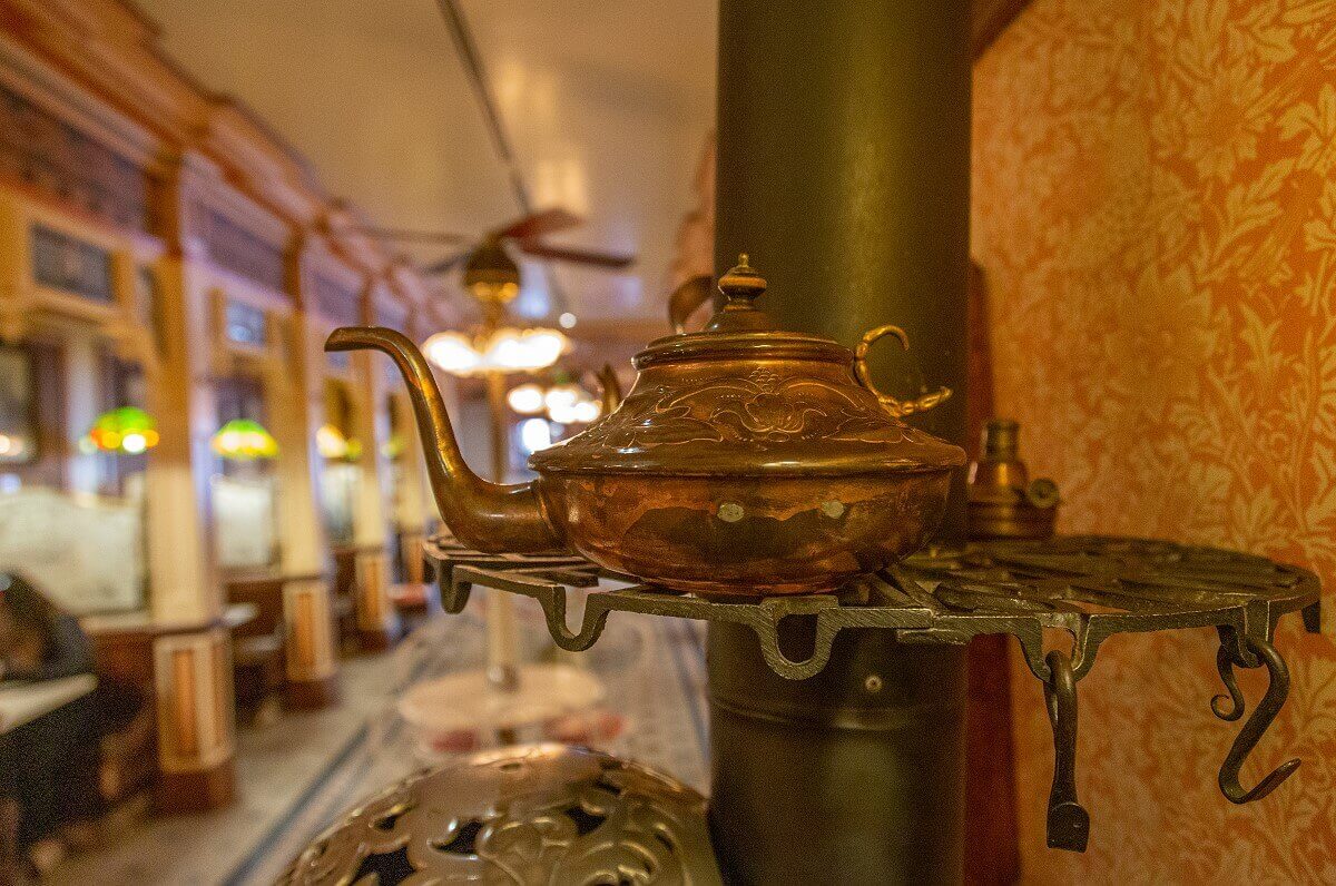 Tea kettle Tea kettle on a shelf on the stovepipe of the wrought iron stove