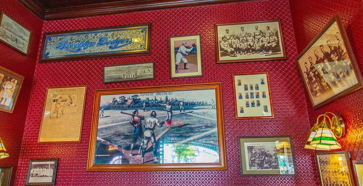 A corner in the guest room with many pictures A corner in the guest room with lots of pictures of baseball, newspaper clippings and a mirrored Brooklyn Dodgers sign