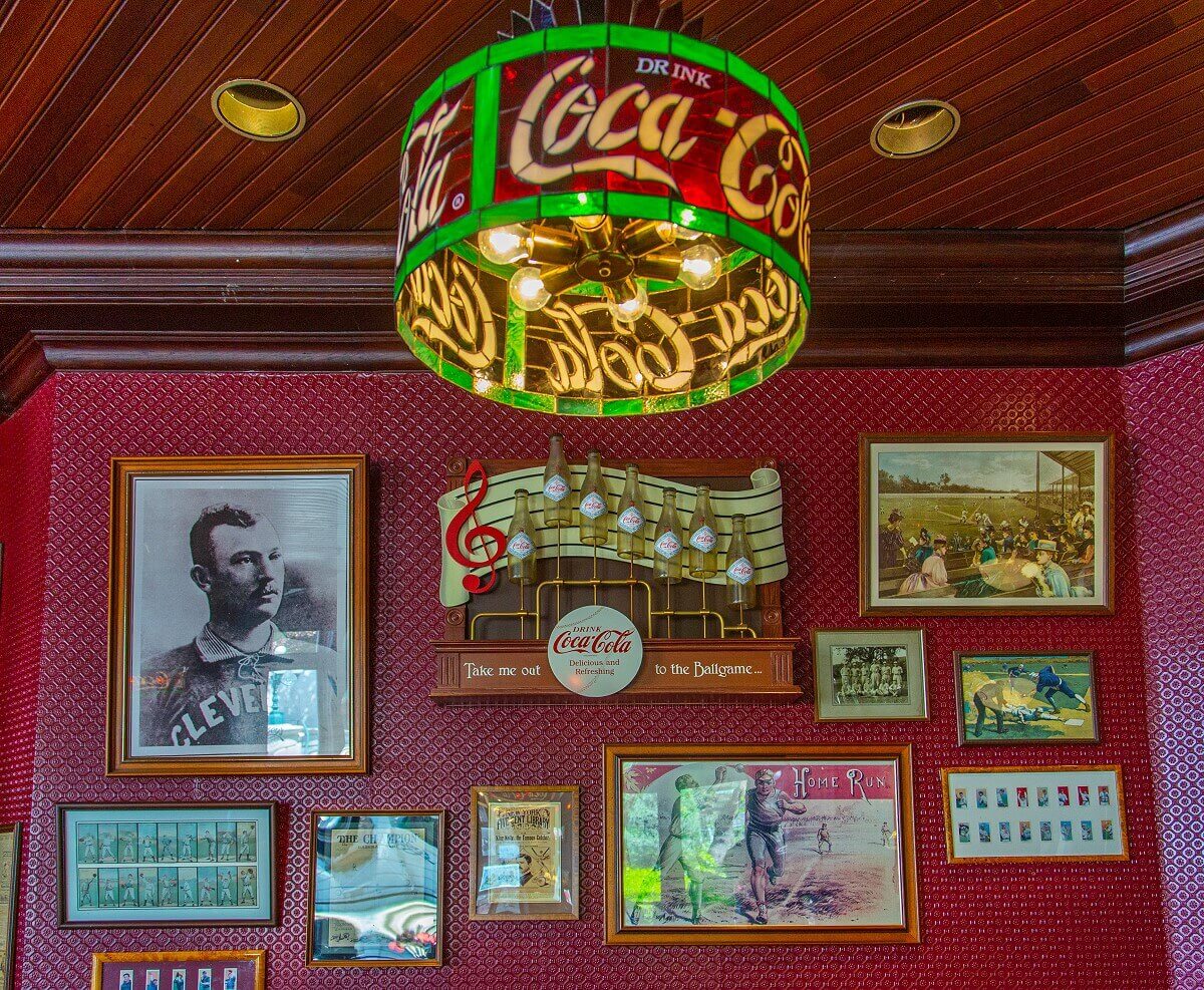 Wall with baseball memorabilia Wall with baseball memorabilia: photos, trading cards, Coca Cola advertising sign for Take me Out to the Ballgame