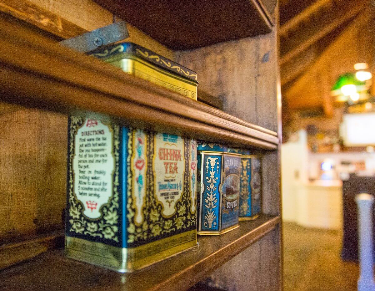 Shelf with tea caddies several old tea tins are standing in a shelf in Colonel Hathis Pizza Outpost