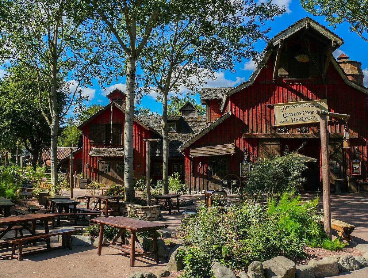 Seating area in front of the restaurant In front of the Cowboy Cookout Barbecue there are some benches and tables surrounded by large trees