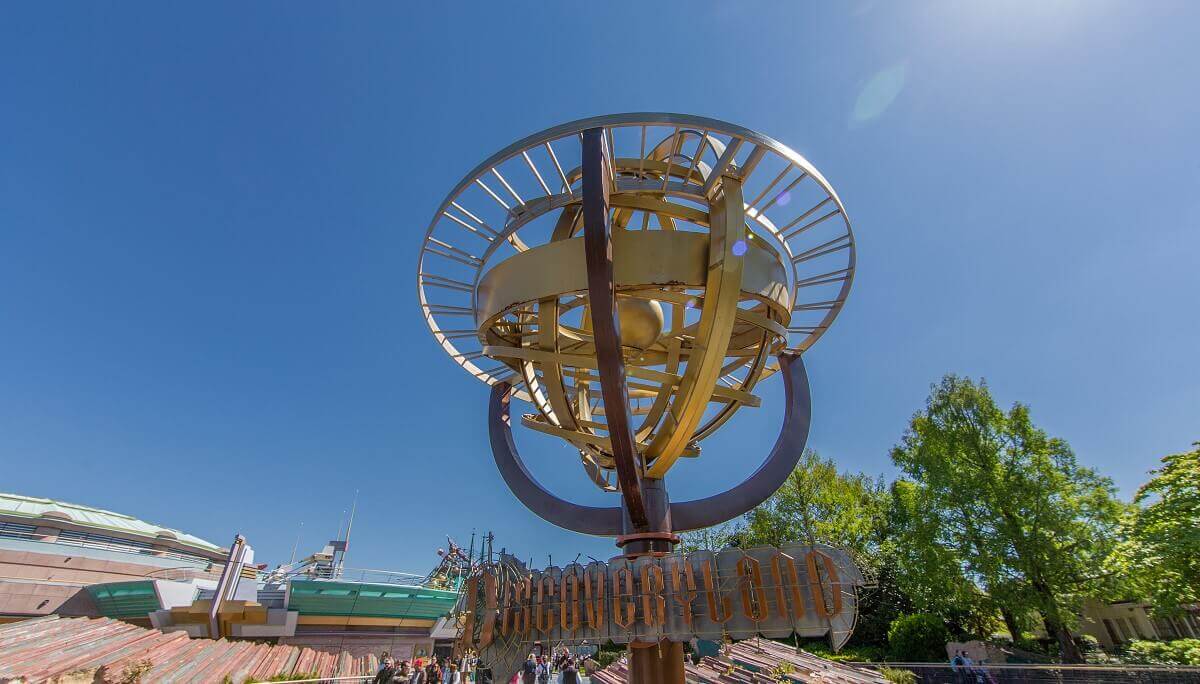 Sign at the entrance to Discoveryland under a metal representation of the solar system with rings, a sign reads Discoveryland