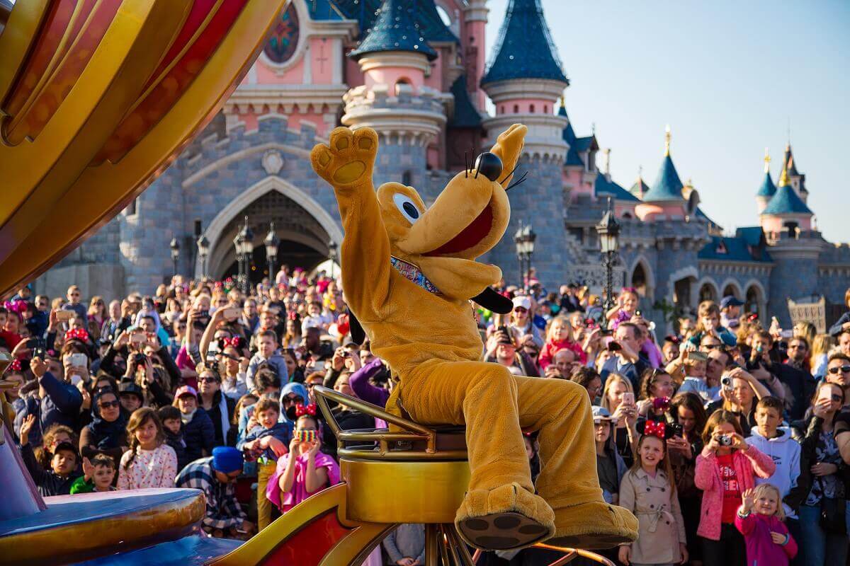 Cheering Goofy Goofy sits in the back of a parade float and cheers for the crowd