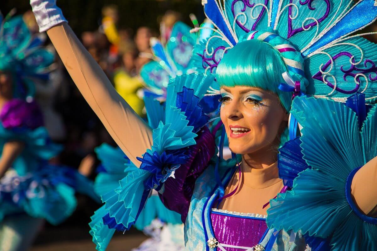 A parade dancer at Disneyland Paris A parade dancer at Disneyland Paris wears a turquoise wig and a costume in turquoise and light blue with purple elements