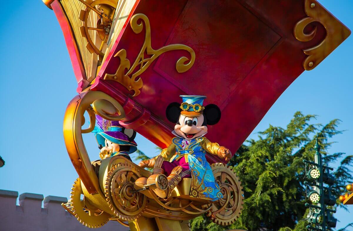 Mickey Mouse in steampunk costume Mickey mouse in a steampunk costume with a long blue coat with gold and bronze patterns, brown boots and red trousers and a blue hat with a brown peak.