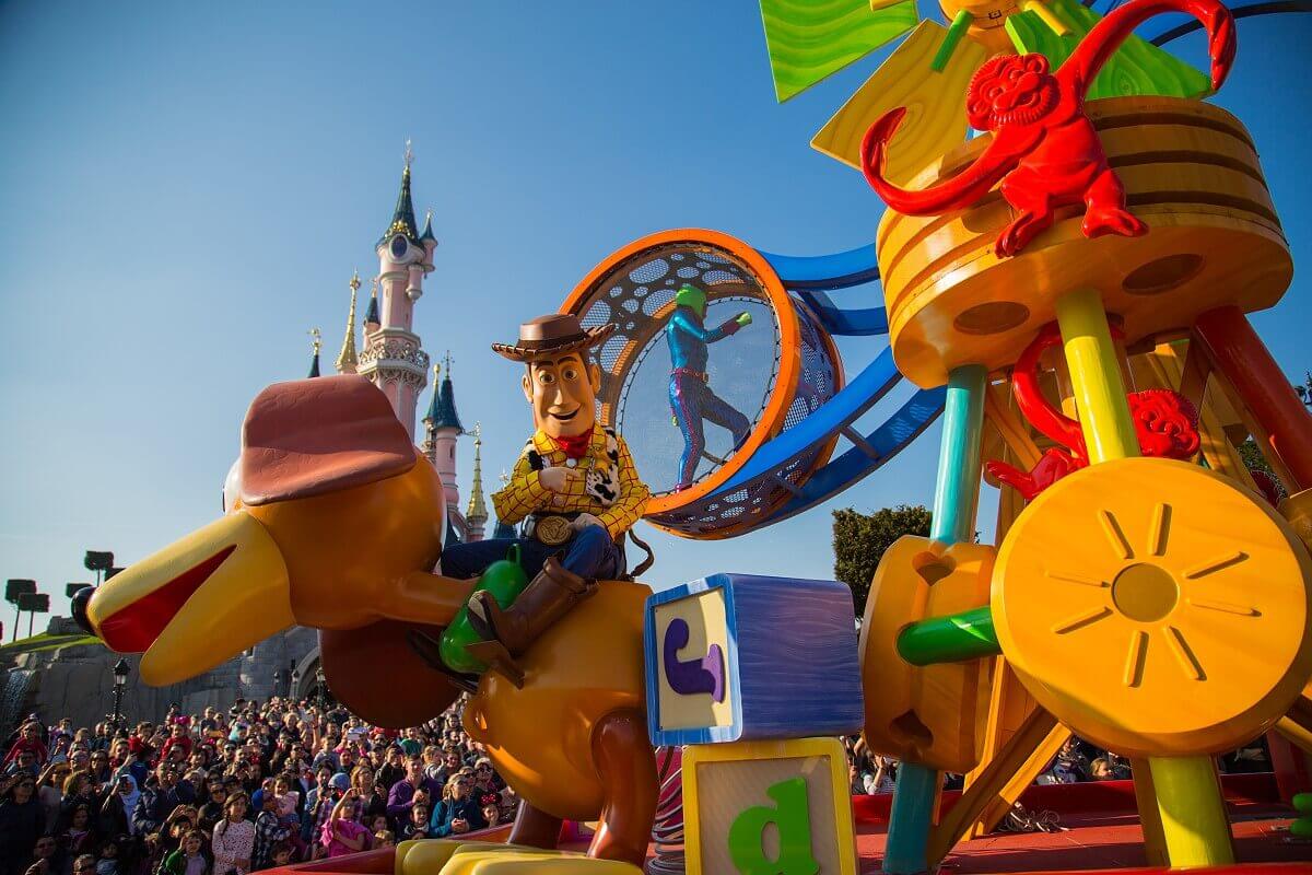 Toy Story Parade Float The colorful Toy Story parade float in front of the castle. Woody rides on Slinky dog, behind him a tower of toys is built up