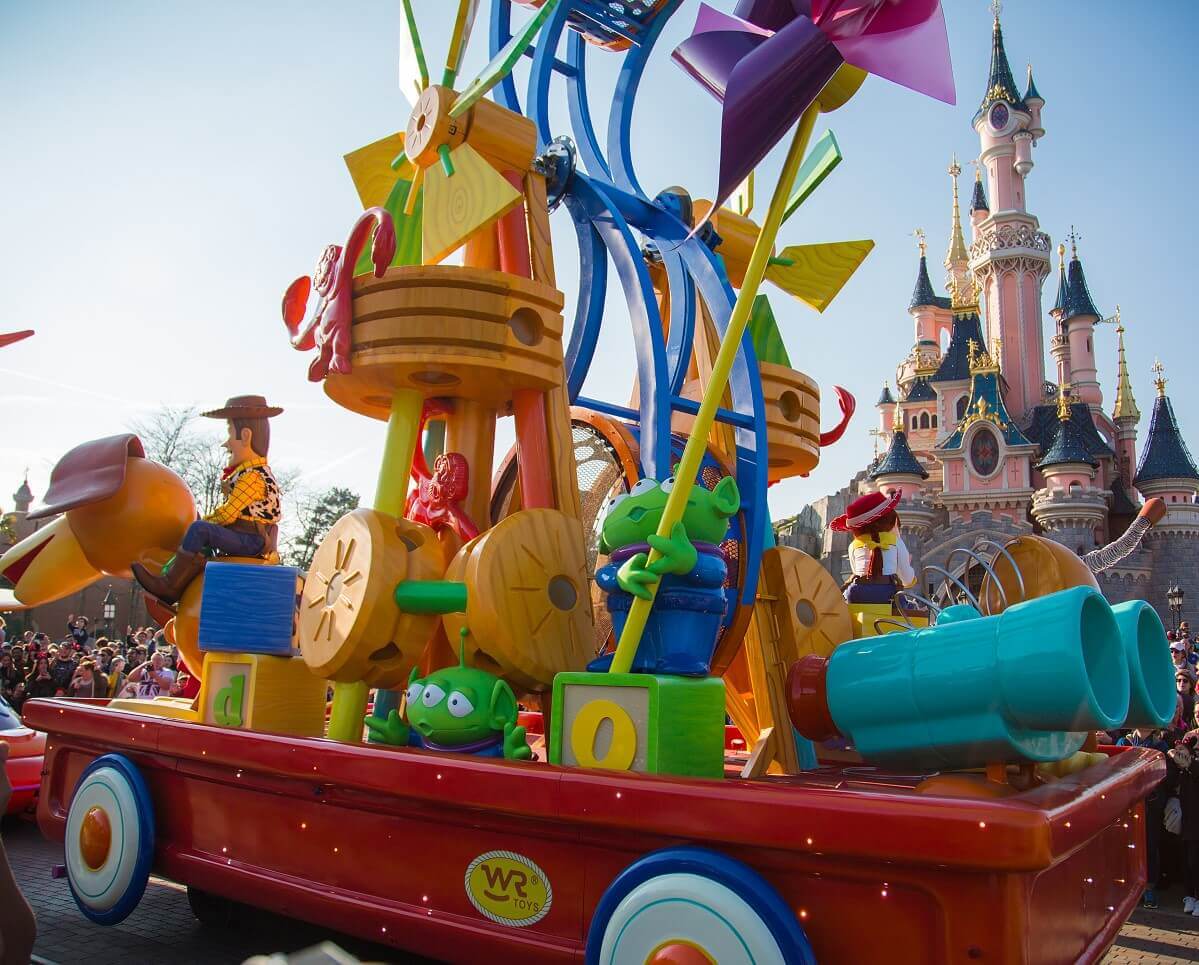 Toy Story parade float in front of the castle Side shot of Toy Story parade float with two green aliens and a giant tower of toys