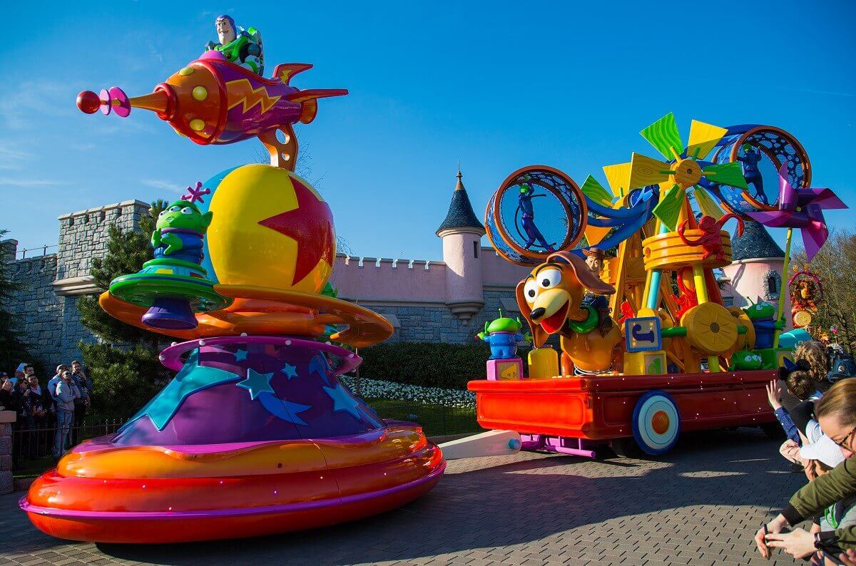 Toy Story Two Piece Parade Float The Toy Story parade float. In front Buzz Lightyear in his rocket on the Pixar Ball, behind Slinky dog and Woody with a toy construction.