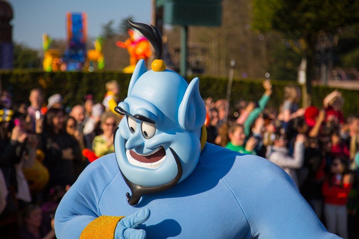 Genie Djinni in close-up, in the background, somewhat blurred, the audience of the parade