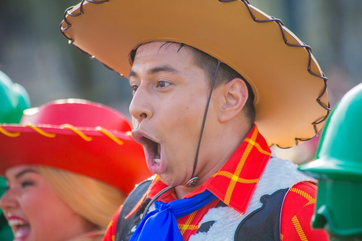 Singing parade dancer A dancer in woody's costume has his mouth wide open and sings at the top of his lungs