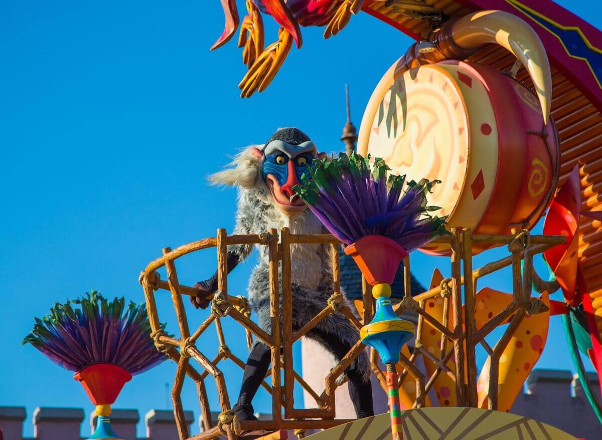 Rafiki on the parade float Rafiki holds onto a wooden railing as the Lion King parade float passes through Disneyland Paris
