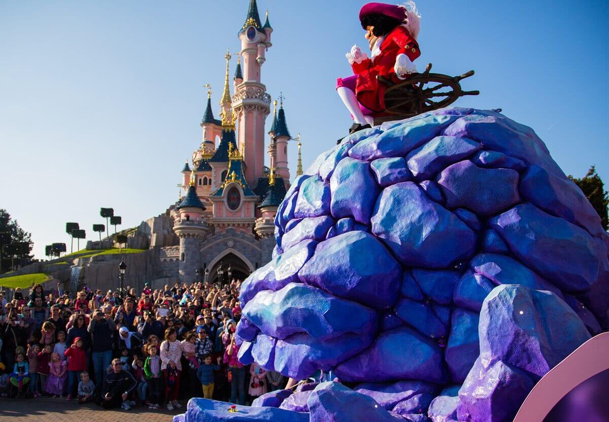 Captain Hook on Skullduggery A huge skull and crossbones, on which Captain Hook is seated, forms a parade float that is just pushing its way in front of the castle