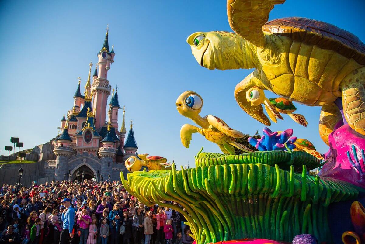 Crush in front of the castle The parade float with Crush, Squirt and the Dudes drives in front of Sleeping Beauty Castle, where numerous spectators are waiting