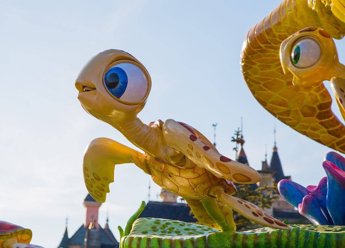 Turtle child on the parade float The Racker siblings on the Finding Nemo parade float