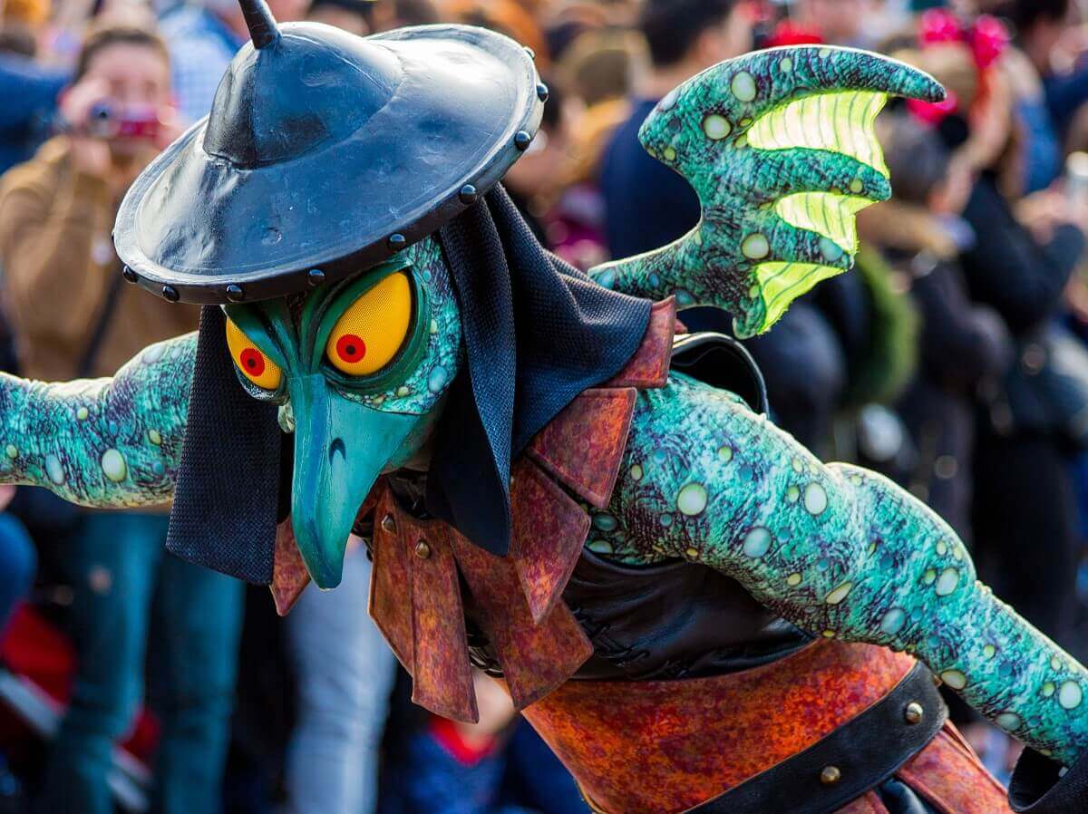 Fabulous creatures at the parade A mythical creature with dragon wings on its back and a bird's beak dances in the parade