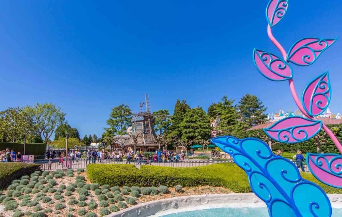 View of the Old Mill View past flowerbeds to the wooden Old Mill and a path along it