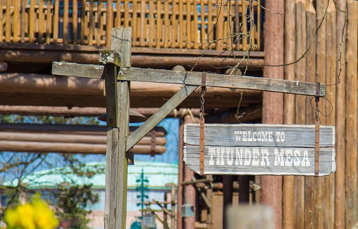 Sign at the entrance to Frontierland A wooden sign that reads Welcome to Thunder Mesa at the entrance to Frontierland.
