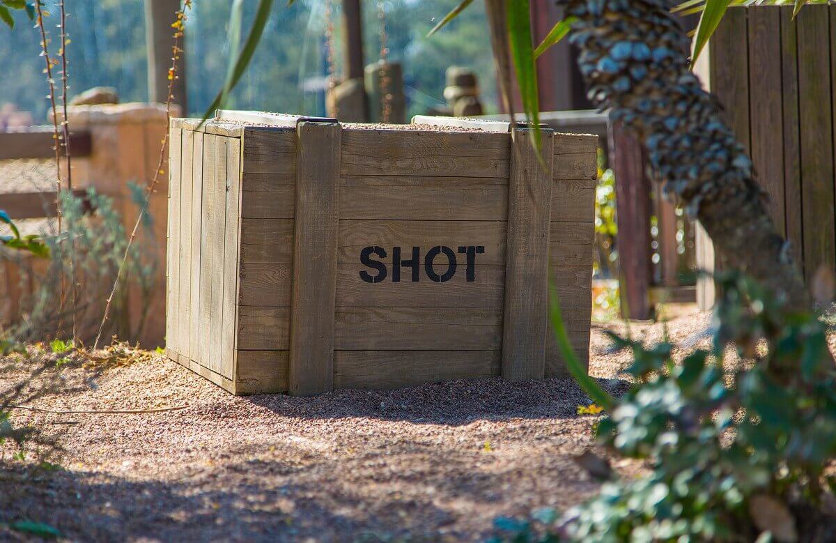 Wooden box In a fenced-in area in Frontierland, there is a box labeled Shot