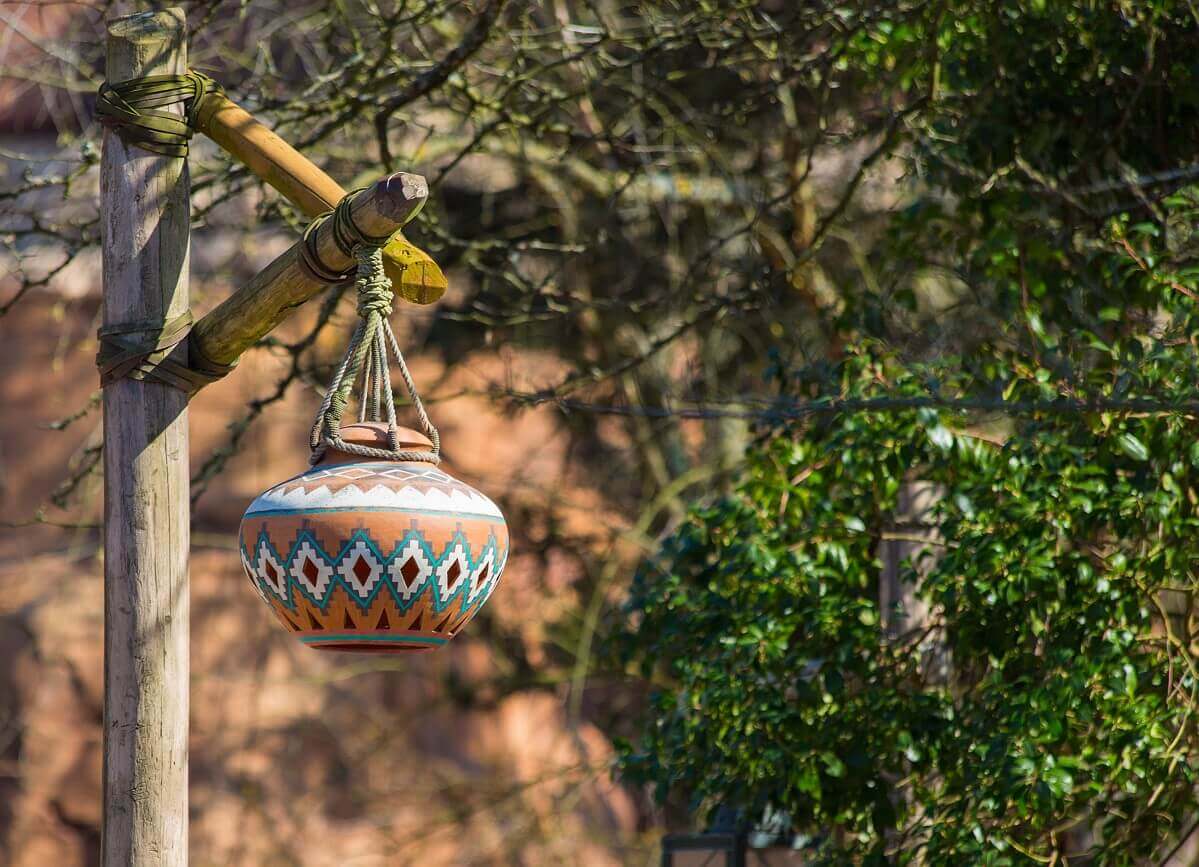 Extraordinary lantern From a wooden trunk hangs a fancy lantern with a pattern reminiscent of indigenous groups of Central America