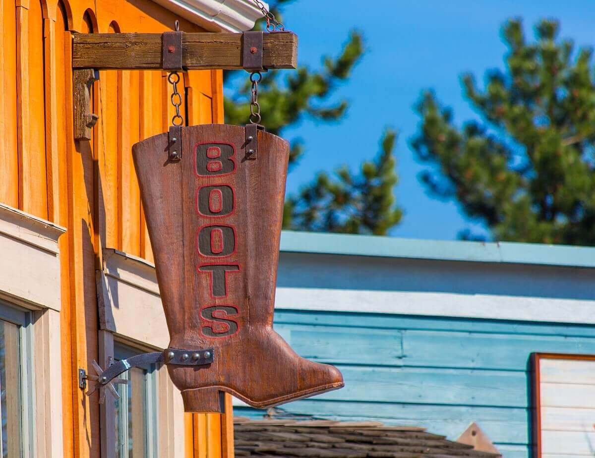 Shield in the shape of a boot A wooden sign in the shape of a cowboy boot hangs from a store in the small town of Thunder Mesa in Frontierland