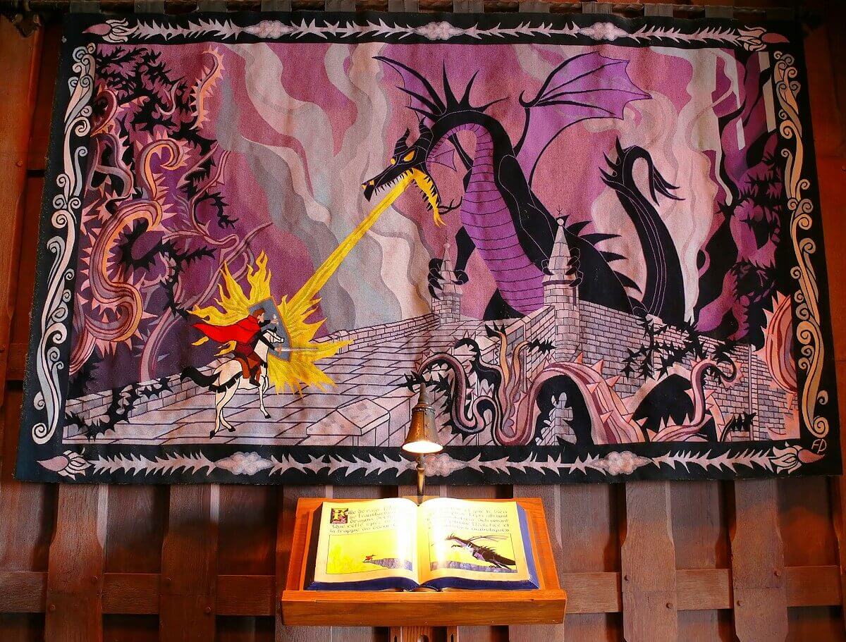 Tapestry with fire breathing dragon A tapestry shows the scene from Sleeping Beauty, in which the brave prince on his horse fights the fire-breathing dragon Malefiz