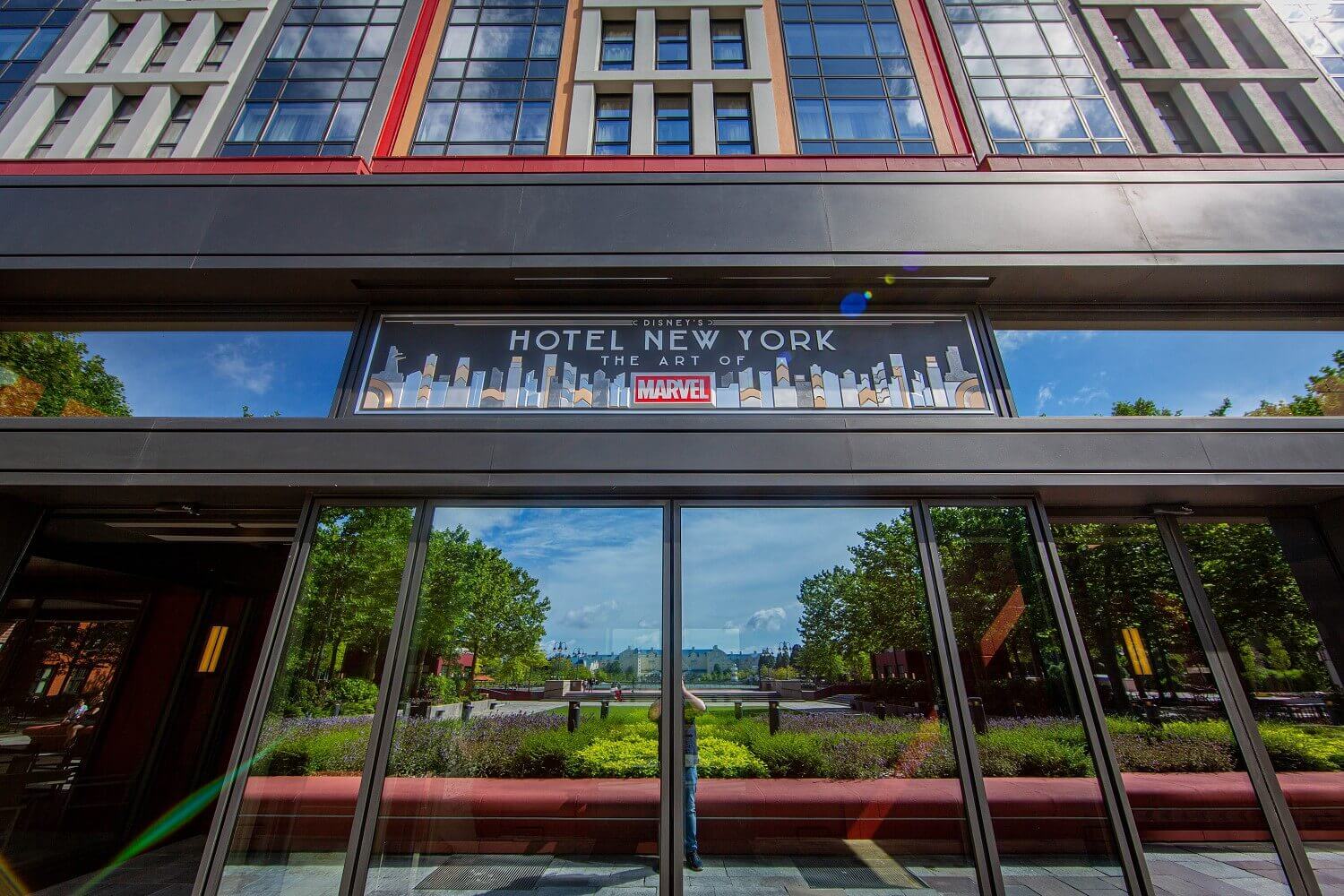 Main-Entrance of the hotel Main entrance of the the hotel. Above the glass door is a sign with the inscription Disney's Hotel New York The Art Of Marvel.