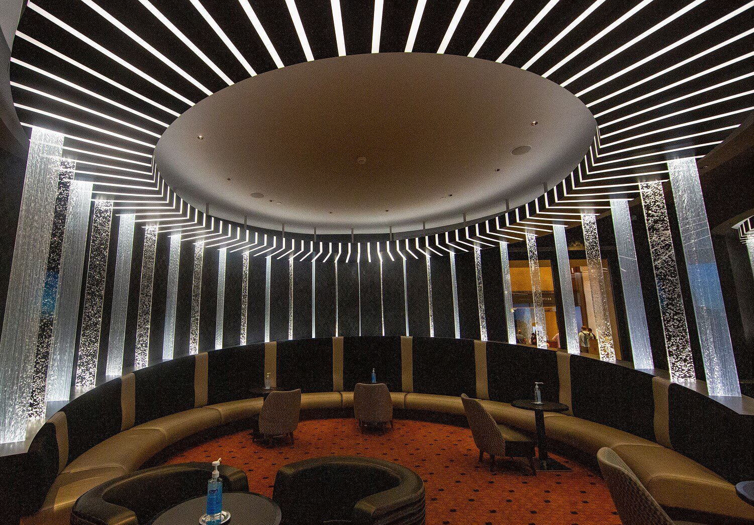 Skyline Bar Lounge in the shape of a semicircle. Columns of water protrude from the armrests and extend to the ceiling lighting.