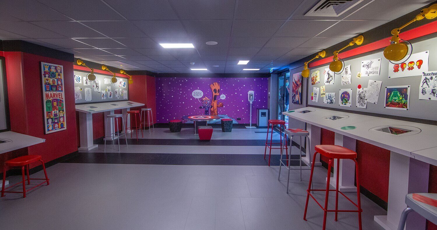 Marvel Design Studio Glance into the Marvel Design Studio. Drawing tables are set up on the sides and pictures hang on the walls.