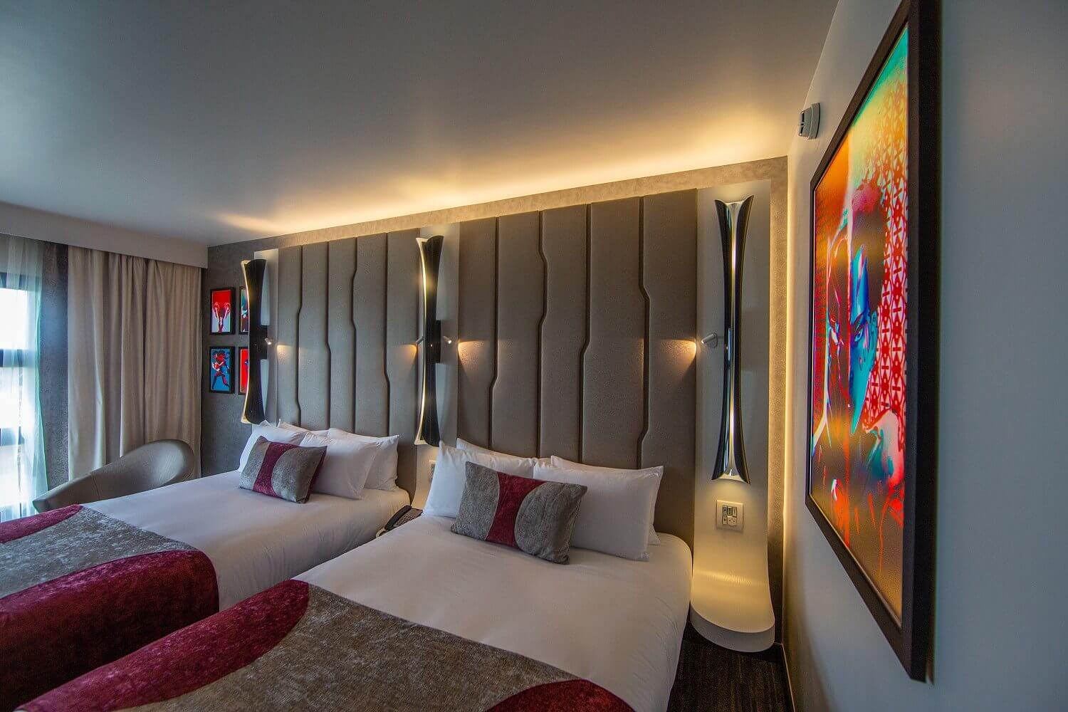 Empire State Club hotel room View of a hotel room in the Empire State Club with two French double beds. Marvel artwork hangs on the walls.