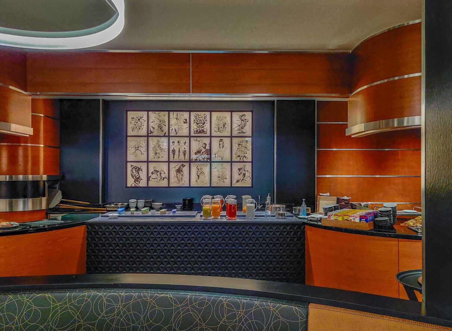 Downtown Restaurant Breakfast buffet with various juices, milk and corn flakes. A picture of Marvel on the wall.