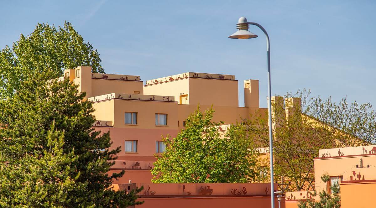 Santa Fe Hotel Building A large orange hotel building, with trees in between. In the foreground is a street lamp.