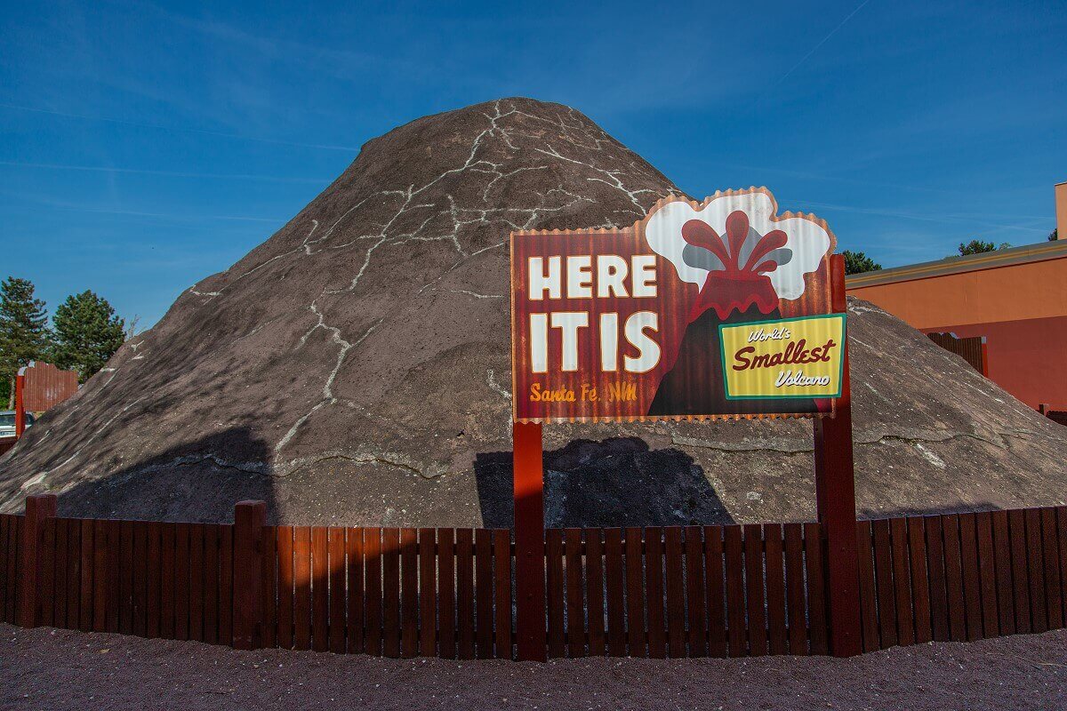 Volcano on the hotel grounds A large fenced volcano stands on the hotel grounds. In front of it a sign reads HERE IT IS World's Smallest Volcano.