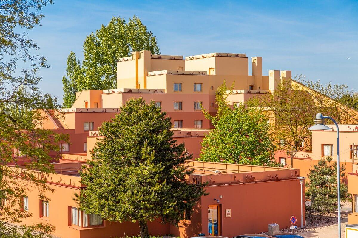 Santa Fe Hotel Building A large orange hotel building, with trees in between.