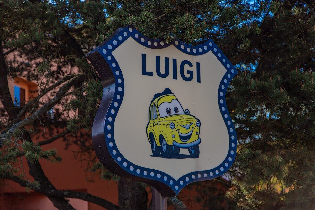 Shield Luigi In front of a hotel building there is a sign with the Cars character Luigi.