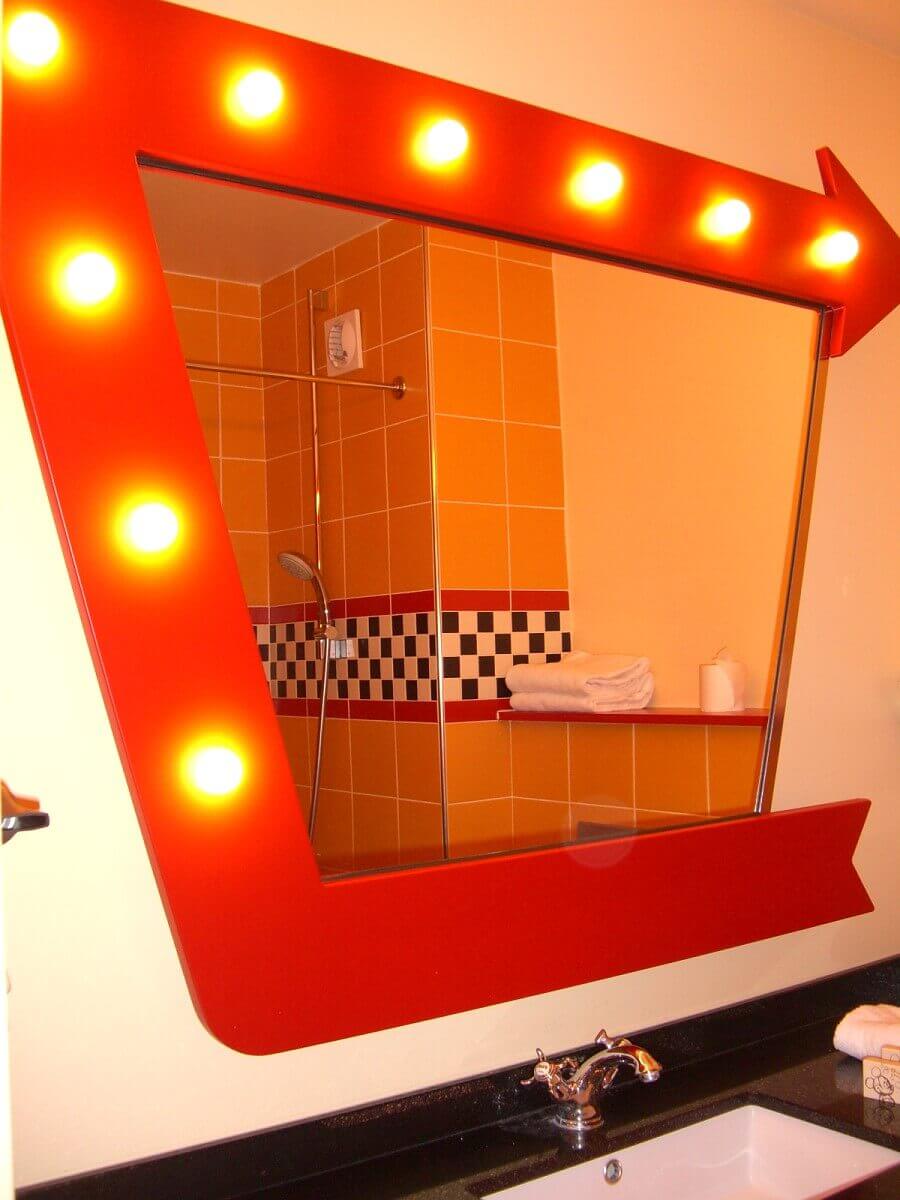 Bathroom mirror In the bathrooms of the Hotel Santa Fe hangs a red framed mirror with small lamps
