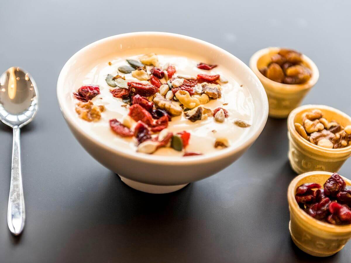 Yogurt A portion of yoghurt in a small bowl garnished with various toppings