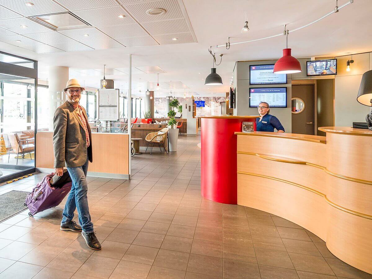 Reception A guest with a suitcase enters the reception of the Inis Hotel