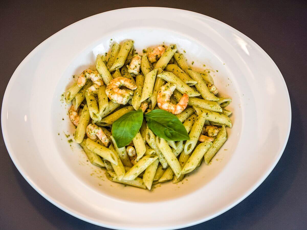 Pasta dish Pasta with pesto and prawns in the restaurant of the Ibis Hotel